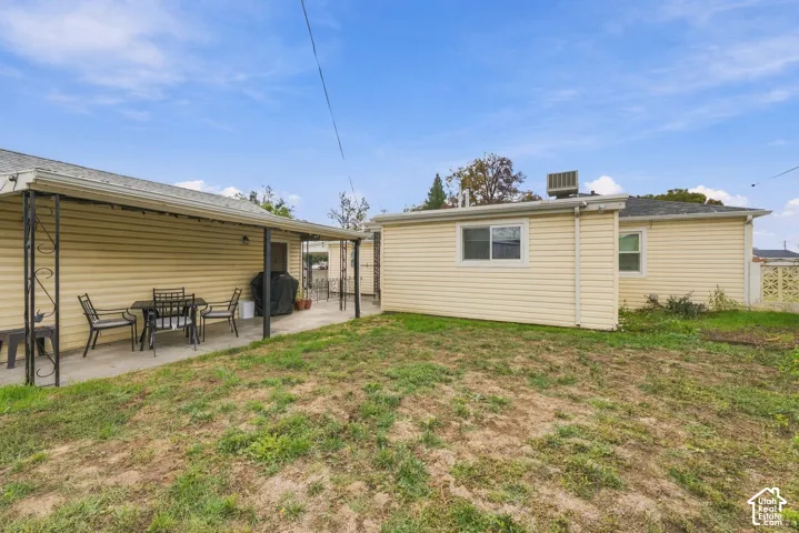 large back yard with covered concrete patio