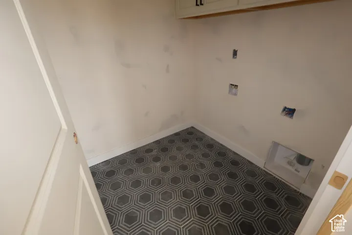 Hexagon patterned tile flooring, built-in upper cabinetry with matte black hardware, and wall-mounted utility hookups