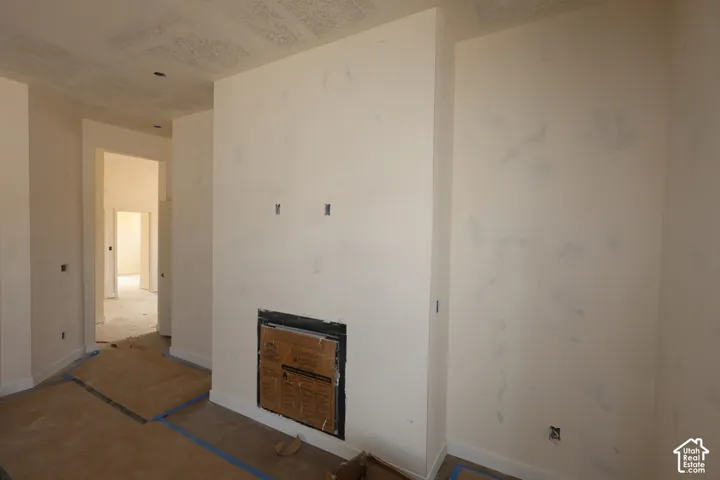 Interior space featuring a recessed fireplace with a metal surround, textured ceiling, and neutral wall finishes