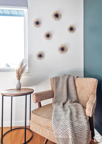 Interior space featuring wood-finish flooring, a neutral-toned wall with textured decorative accents, and a contrasting deep-toned accent wall