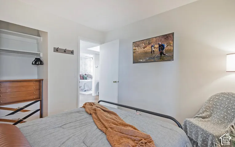 Built-in closet with shelving, metal wall-mounted hook rack, and neutral interior paint