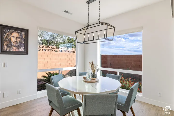 Large windows with white frames, wood-finish flooring, and a modern geometric pendant light fixture