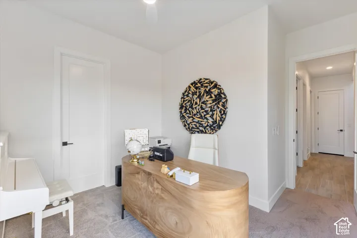 Interior space featuring neutral wall tones, recessed lighting, solid-core doors with matte black hardware, and wall-to-wall carpeting