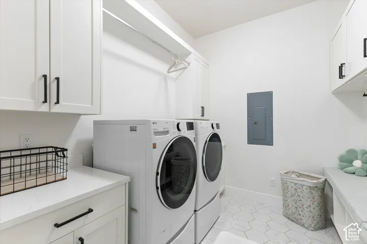 Utility space featuring white shaker-style cabinetry with matte black hardware, stone-composite countertops, built-in hanging rod, and hexagonal tile flooring