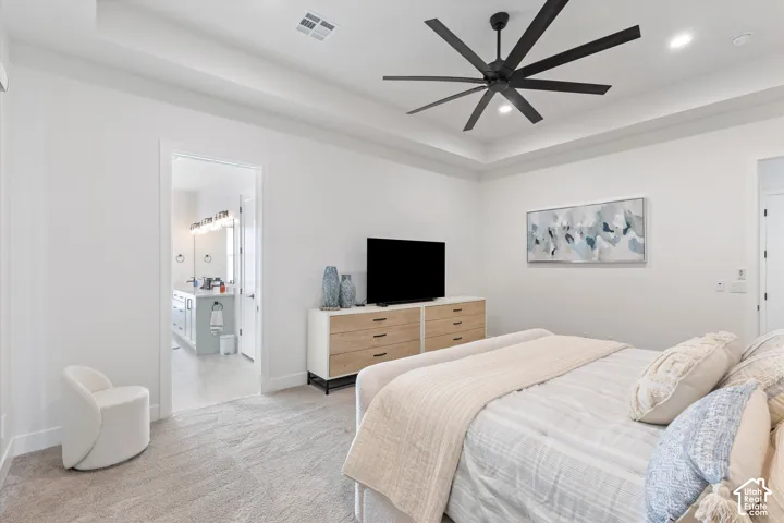 Tray ceiling featuring a large matte black ceiling fan, neutral wall-to-wall carpeting, and recessed lighting