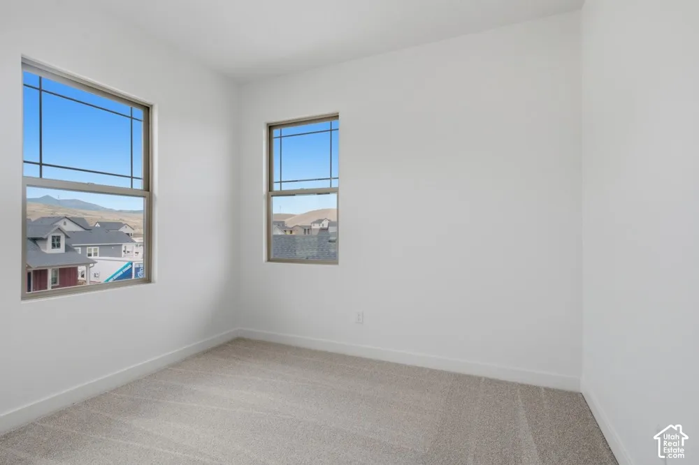 Neutral-toned carpeting, high-contrast grid-pattern windows, and mountain-range backdrop
