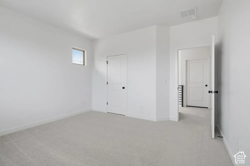 Neutral wall-to-wall carpeting, high-profile solid-core doors with matte black hardware, and an elevated square transom window