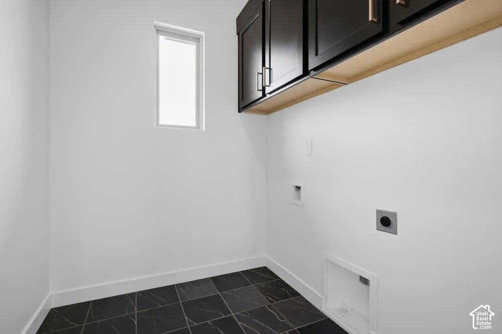 Dark wood-finish cabinetry, rectangular tile flooring, and a vertical window