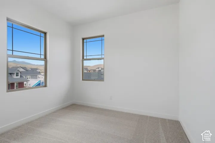 Neutral-toned carpeting, high-contrast grid-pattern windows, and mountain-range backdrop