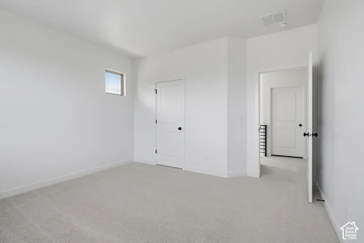 Neutral wall-to-wall carpeting, high-profile solid-core doors with matte black hardware, and an elevated square transom window