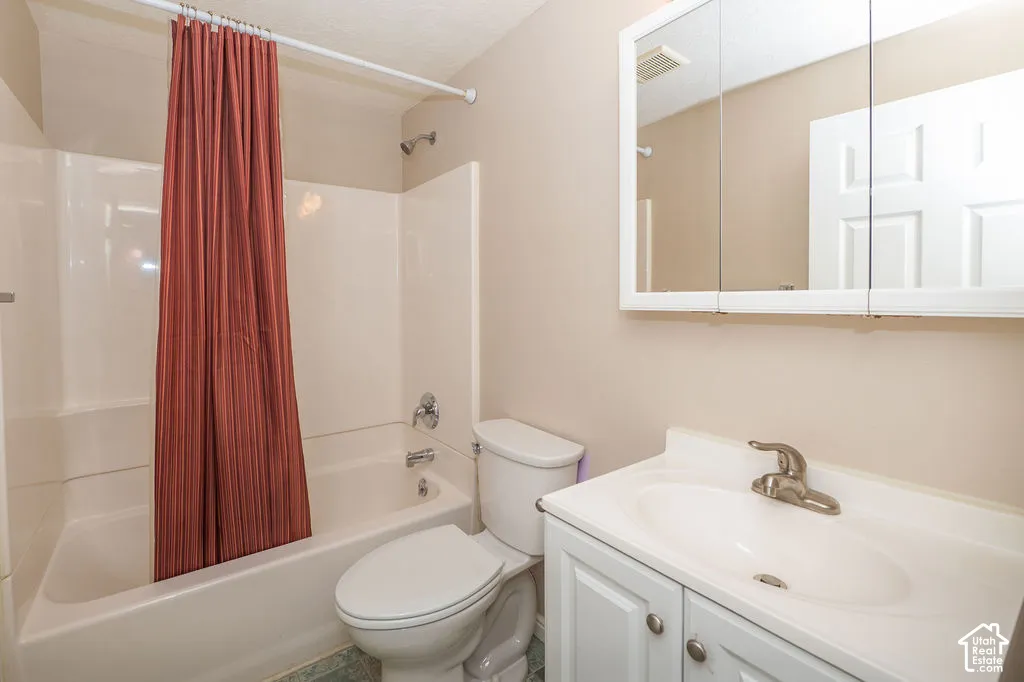 Bathroom featuring a white vanity cabinet with a integrated sink, brushed metal faucet, tri-fold medicine cabinet, and a shower-tub combination with a molded surround