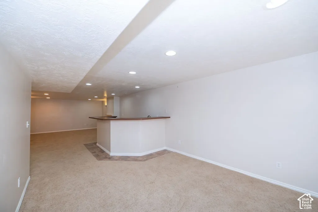 Built-in bar featuring a countertop, recessed lighting, and tile flooring inset