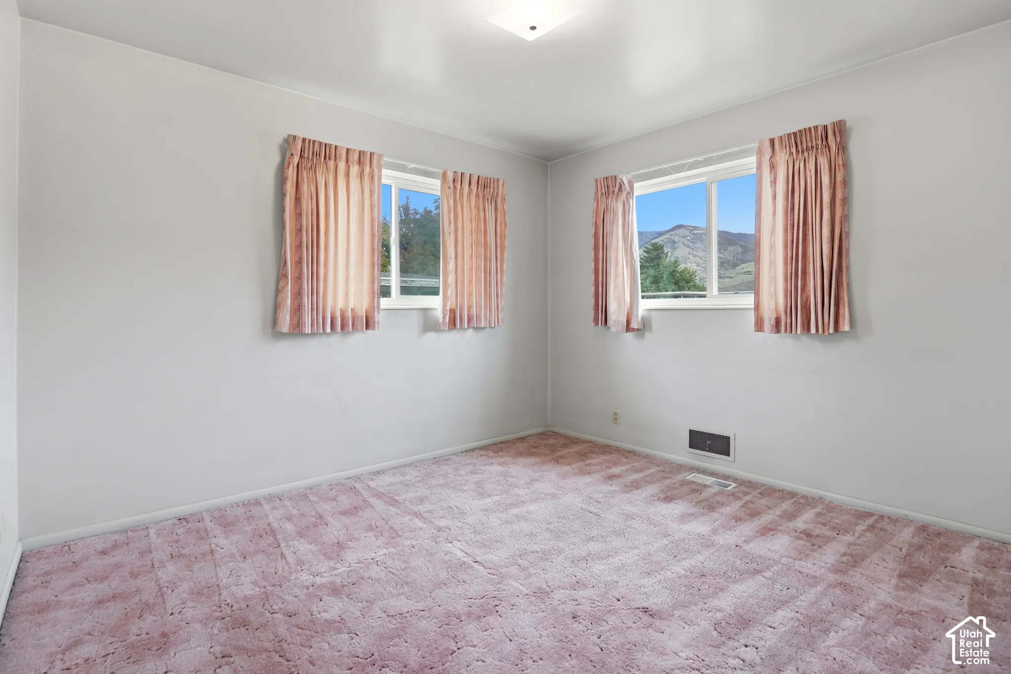 Room featuring wall-to-wall carpeting, dual windows, and mountain scenery