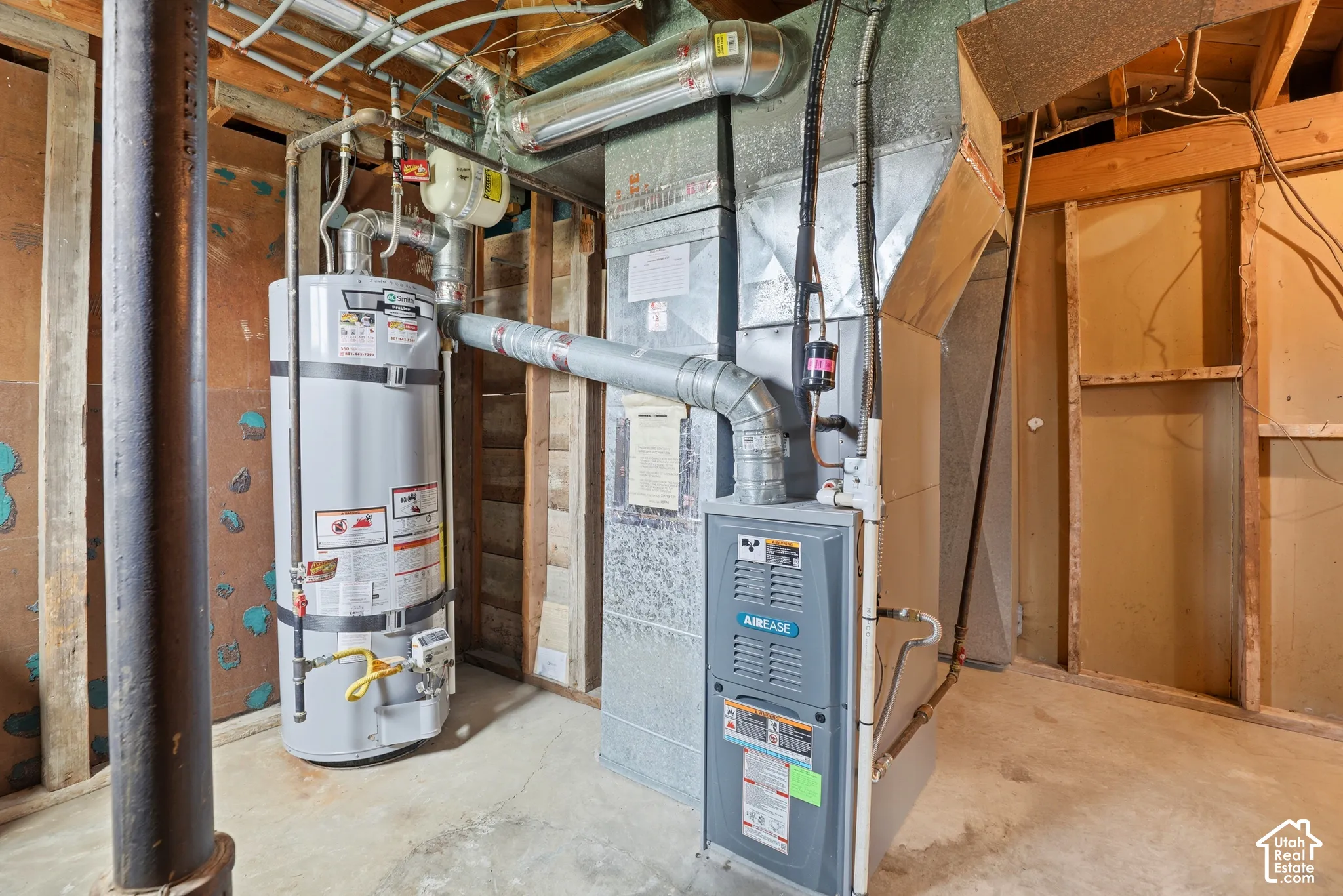 Mechanical area featuring a forced-air furnace, metal ductwork, and a vertical water heater