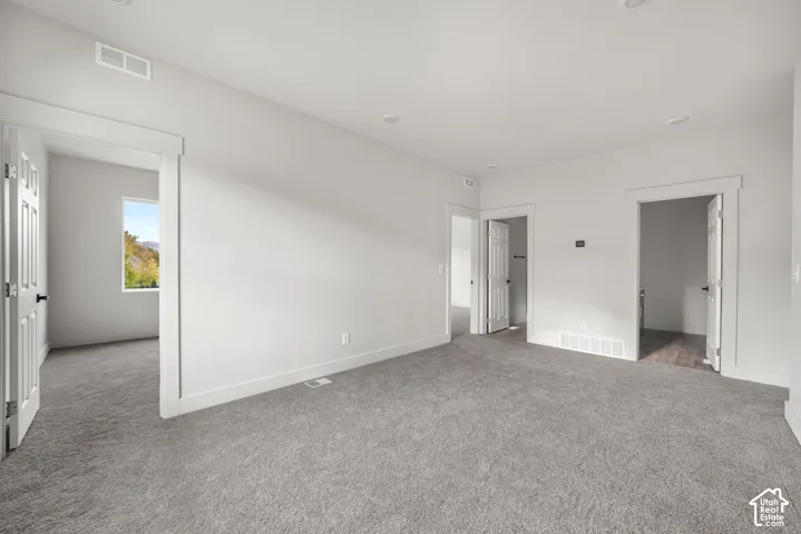 Neutral-toned carpeting, recessed ceiling lighting, and solid-core interior doors with crisp trim molding