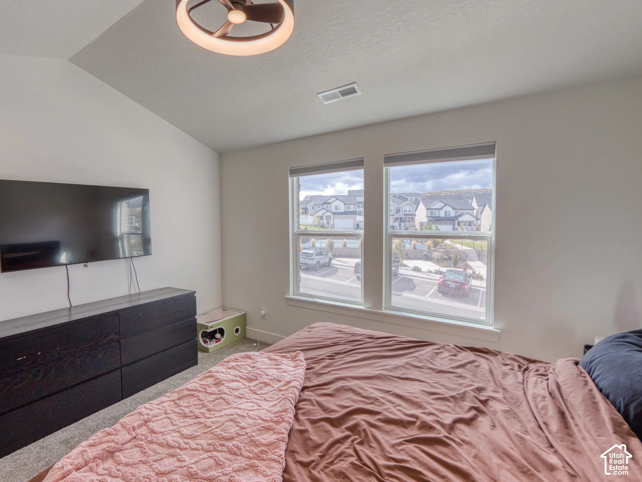 Master bedroom, Vaulted ceilings, neutral wall tones, dual pane windows, and a flush-mount circular lighting fixture with integrated fan