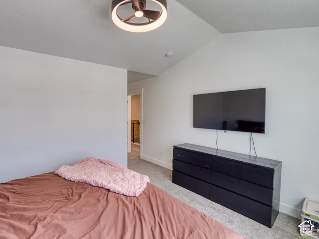 Master bedroom Vaulted ceilings featuring a contemporary circular flush-mount light fixture and neutral carpeting