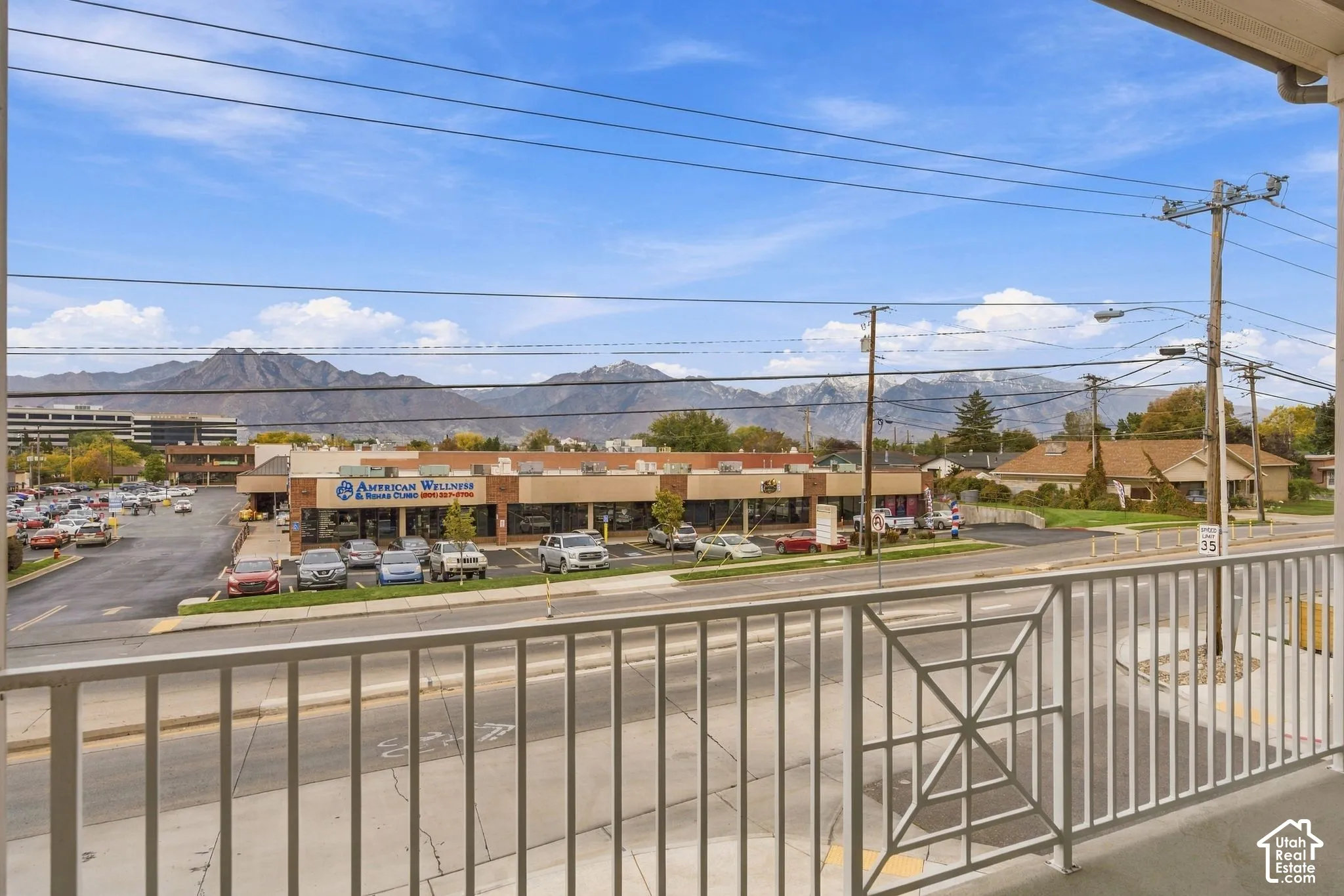 Elevated balcony featuring a white metal railing and a backdrop of mountain scenery