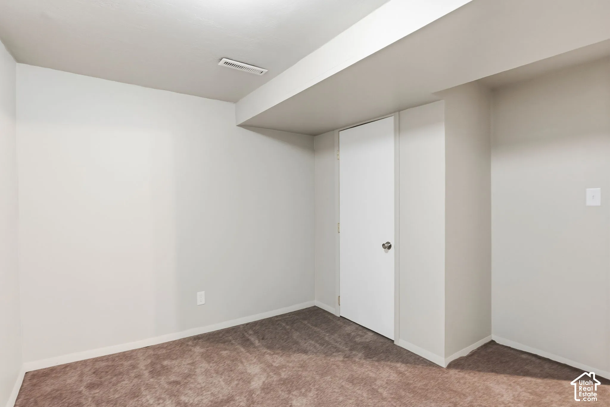 Neutral wall palette, wall-to-wall carpeting, and a single-panel interior door