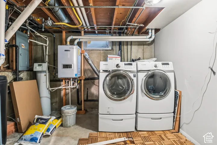 Utility area featuring a wall-mounted tankless water heater, water softening system, and concrete foundation walls with an inset window