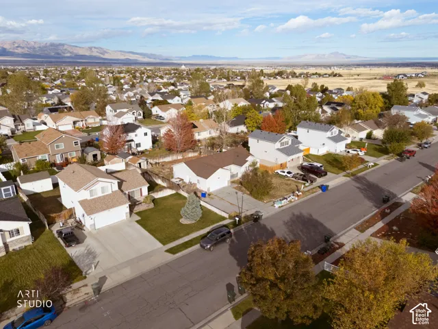 Aerial perspective of residential neighborhood featuring paved streets, established landscaping, and mountain scenery