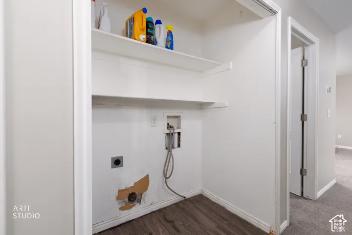 Utility alcove featuring two tiers of built-in shelving and wood-finish flooring