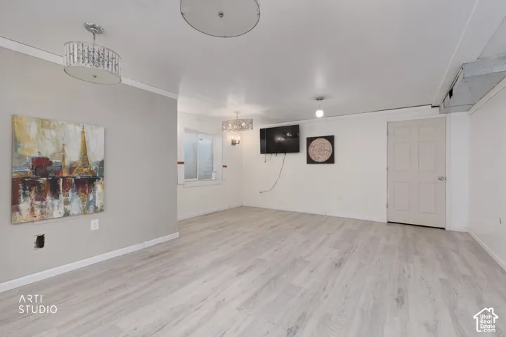 Interior space featuring wood-finish flooring, three decorative drum-style light fixtures, recessed lighting, and a neutral color palette
