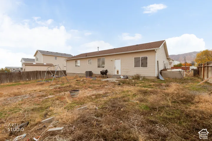 Vinyl siding exterior, asphalt shingle roof, wood privacy fencing, and mountain backdrop