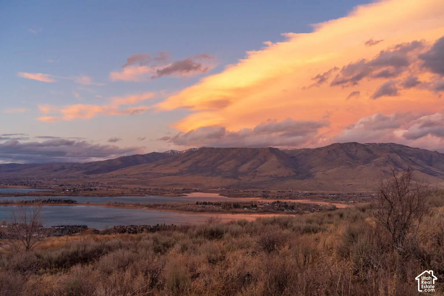 Expansive landscape featuring panoramic mountain ridgelines, waterfront scenery, and native high-desert vegetation