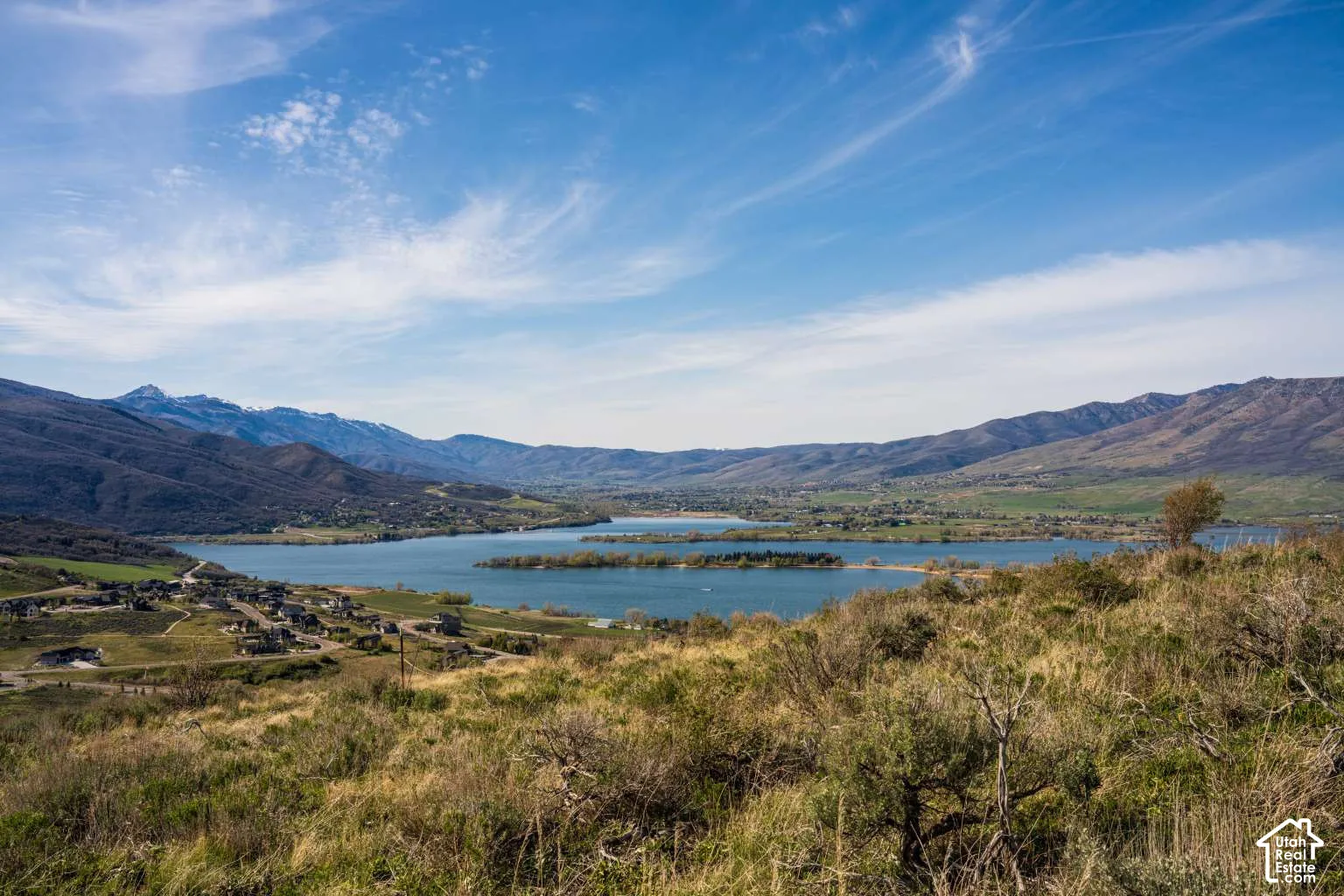 Expansive mountain backdrop featuring a large lake and native hillside vegetation
