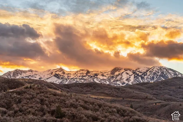 Expansive mountain landscape featuring snow-capped peaks and rugged, rolling terrain