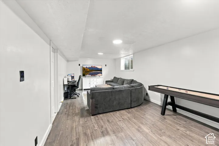 Finished interior space featuring wood-finish flooring, neutral white walls, recessed ceiling lighting, and a window for natural light