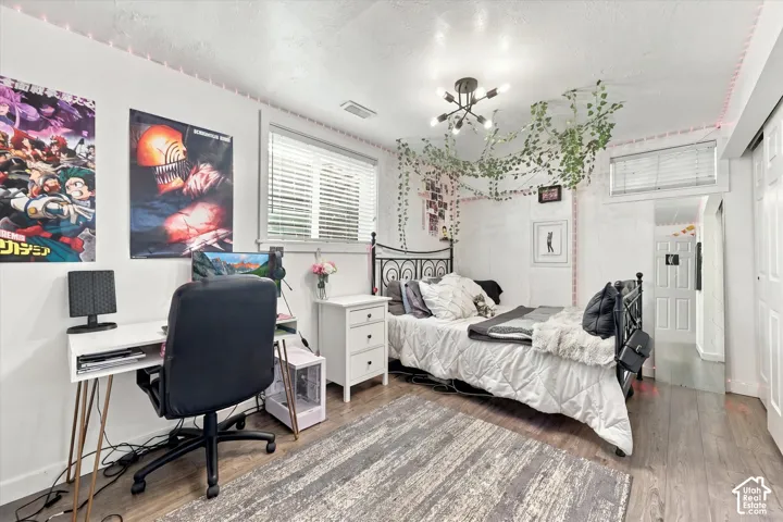 Wood-finish flooring, multi-light geometric ceiling fixture, and horizontal blind window treatments