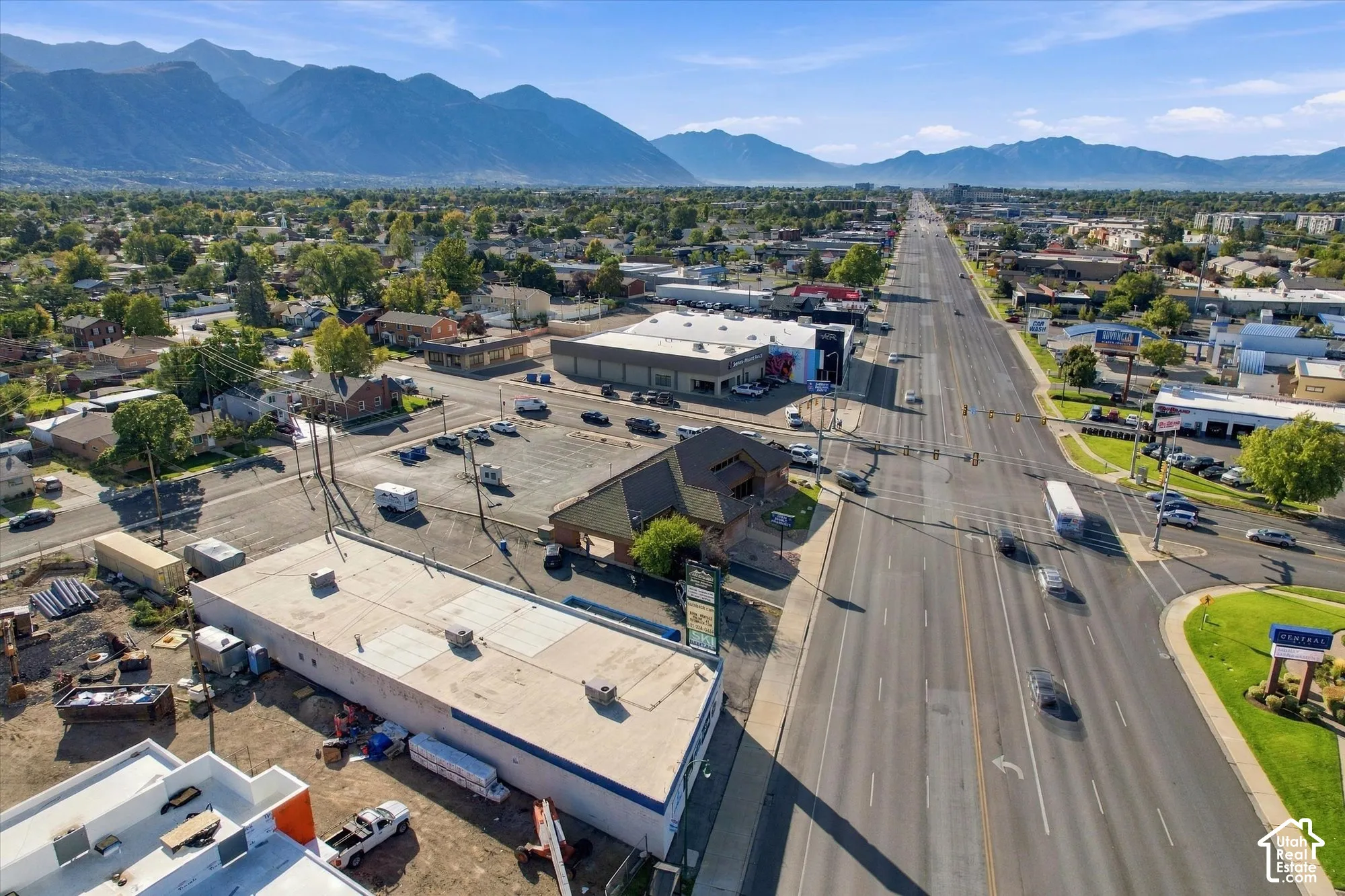 Aerial perspective highlighting a commercial corner lot with frontage on a primary thoroughfare and mountain range backdrop
