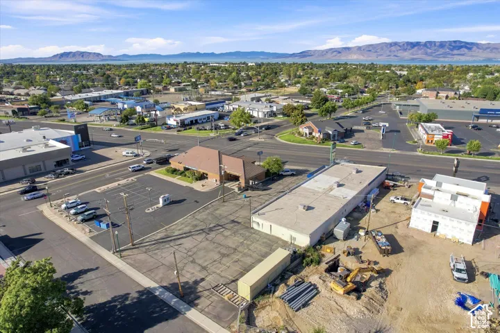 Commercial property featuring paved asphalt surface parking, expansive frontage, and mountain range backdrop