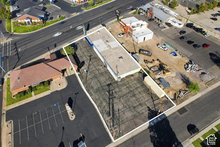 Commercial property featuring a rectangular structure, asphalt-paved lot with marked parking stalls, and street frontage
