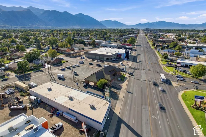 Aerial perspective highlighting a commercial corner lot with frontage on a primary thoroughfare and mountain range backdrop