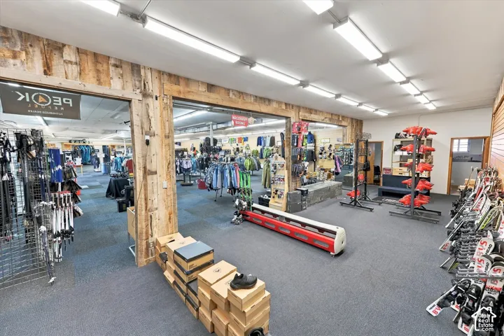 Expansive interior featuring exposed natural timber structural framing, extensive linear overhead LED lighting, and carpeted flooring
