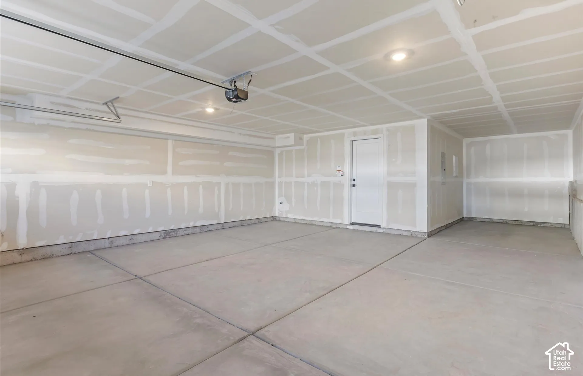 Multi-car garage featuring a concrete floor, recessed lighting, and an integrated garage door opener
