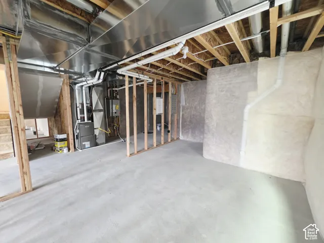 Unfinished basement area featuring exposed timber framing, concrete flooring, batt insulation, and exposed mechanical systems