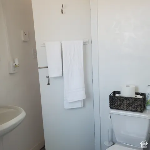 Pedestal sink, wall-mounted hardware, and standard porcelain toilet