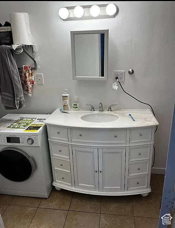 White vanity featuring integrated cabinetry, stone-finish countertop with an undermount sink, three-light vanity fixture, and mirrored medicine cabinet