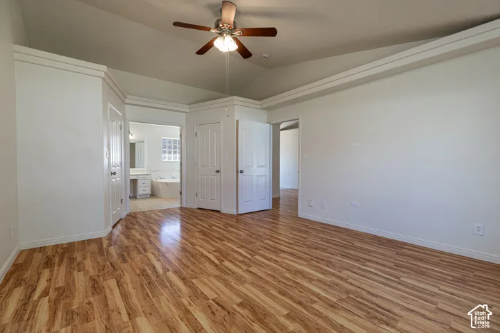 Vaulted ceilings with crown molding, wood-finish flooring, and a ceiling fan with integrated light fixture