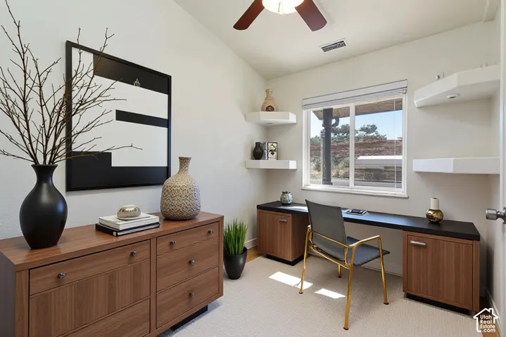 Built-in wood-finish cabinetry, integrated desk space, floating corner shelving, ceiling fan with light fixture, and horizontal sliding window