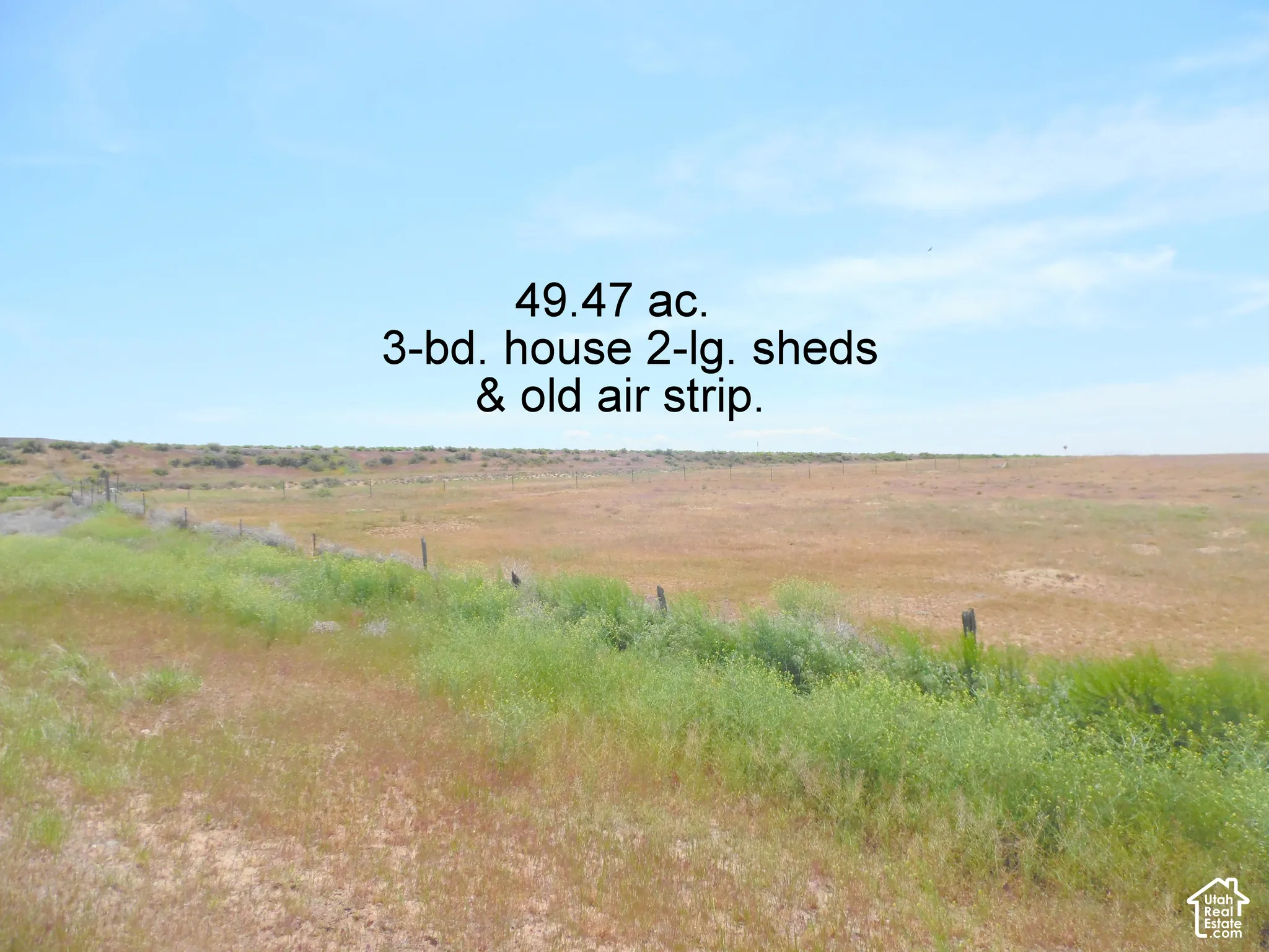 Expansive 49.47-acre parcel featuring open terrain, perimeter fencing, and a leveled strip