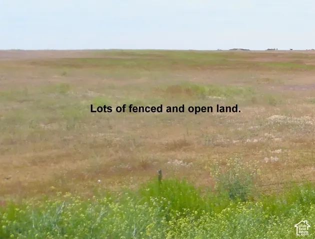 Expansive parcel of open land featuring wire fencing and native vegetation