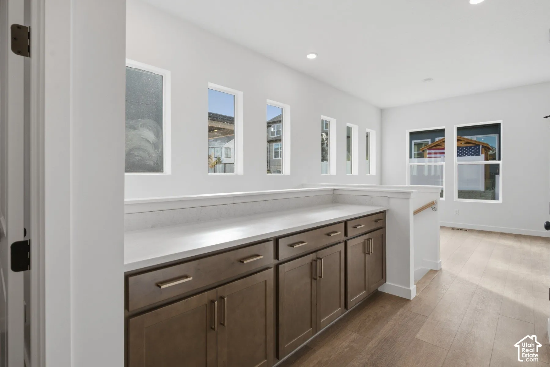 Custom built-in cabinetry with stone-finish countertops, wood-finish flooring, and multiple windows providing natural lighting
