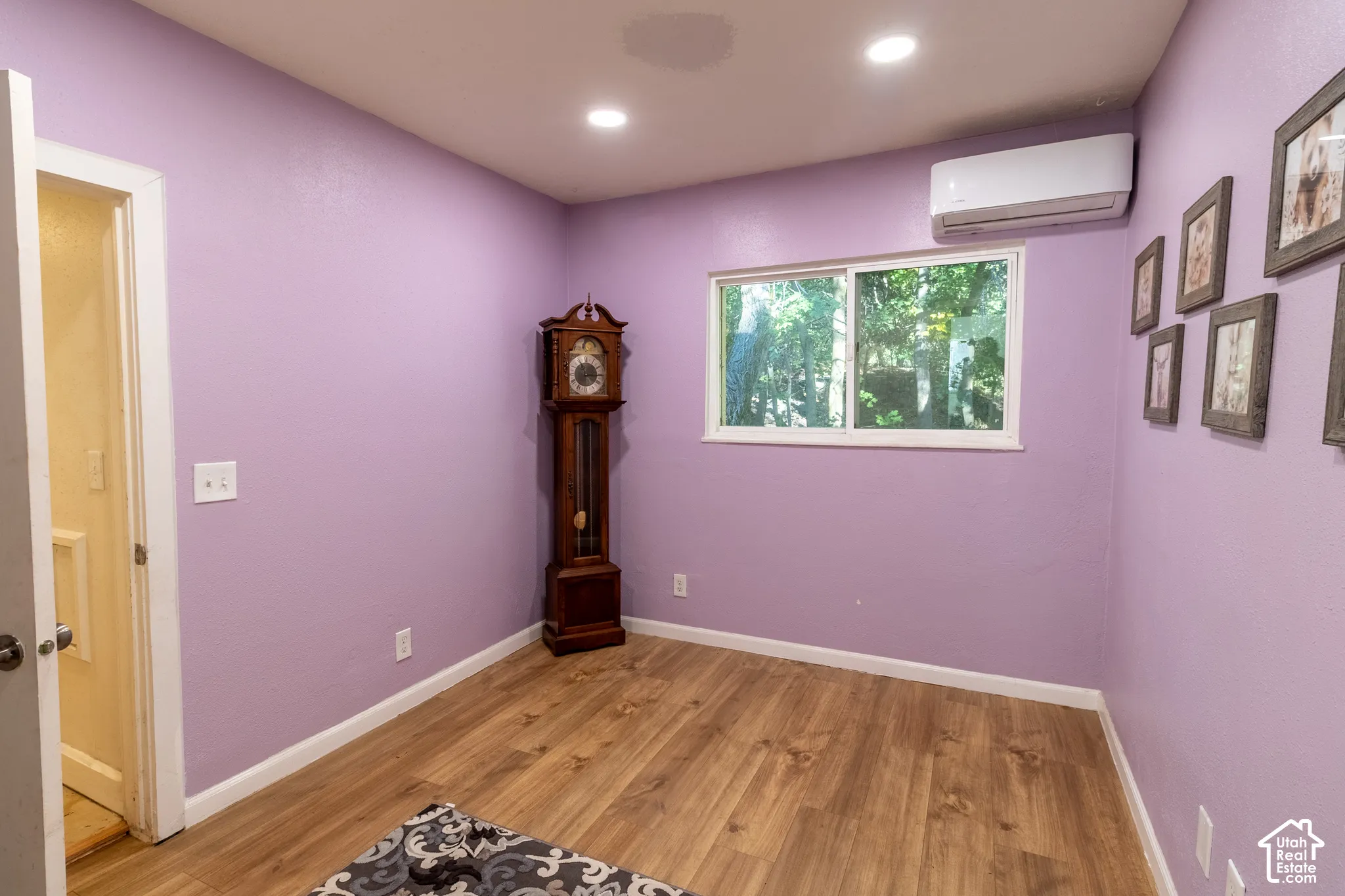 Room featuring wood-finish flooring, recessed lighting, and a wall-mounted ductless mini-split system