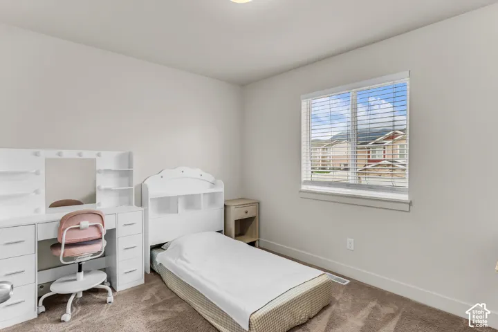 Neutral-toned interior featuring wall-to-wall carpeting and a large window with white horizontal blinds