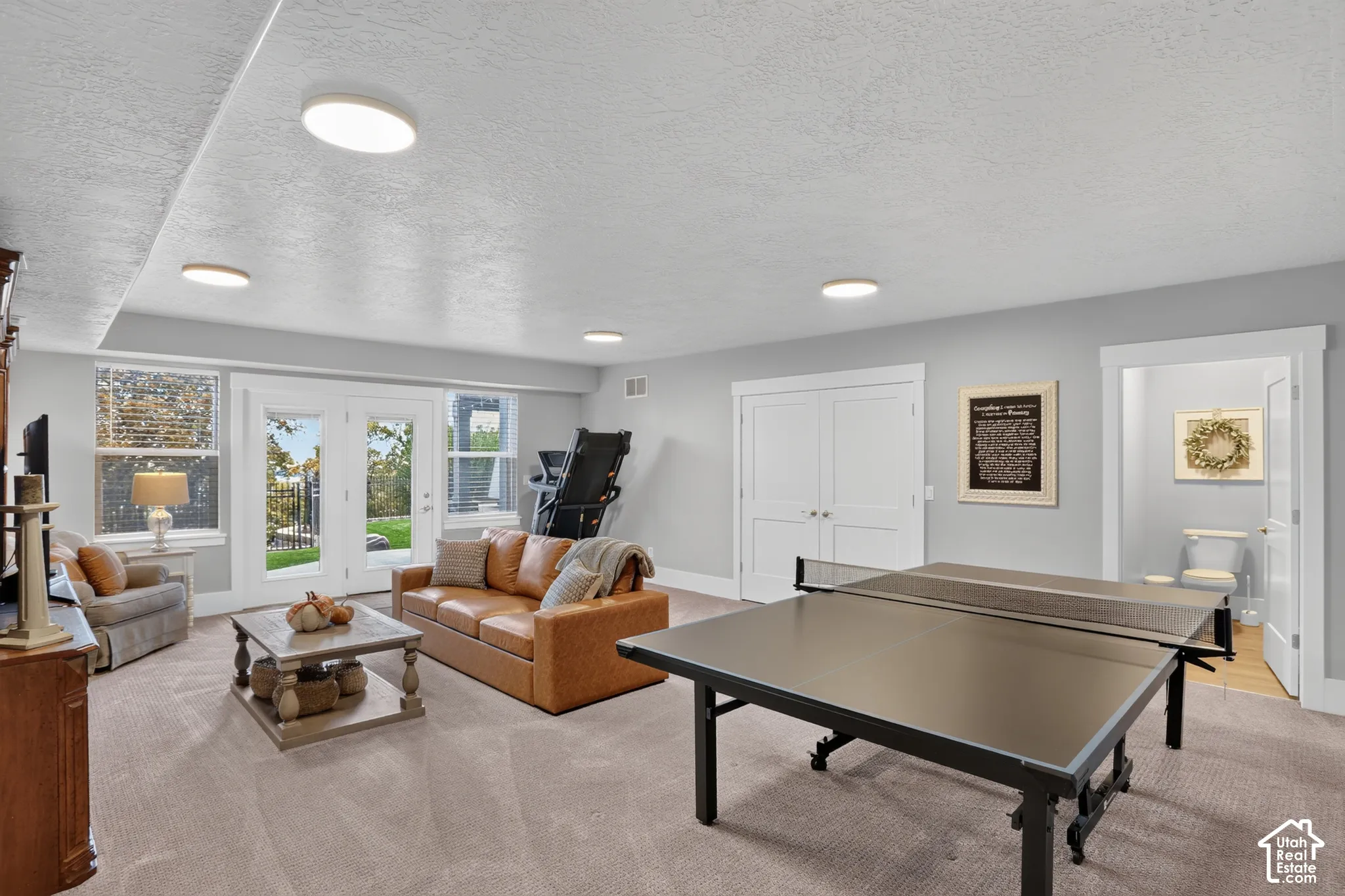Spacious interior featuring wall-to-wall carpeting, recessed ceiling lighting, double-door closet storage, and double glass-paned doors leading to exterior grounds